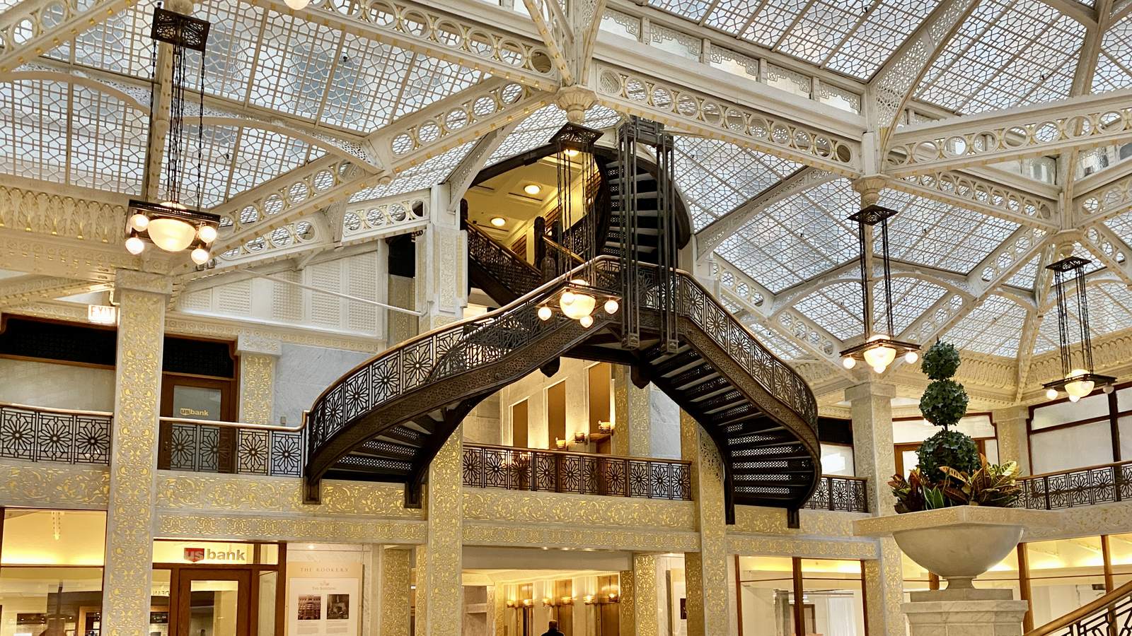 A glass-roofed atrium with a spiral staircase