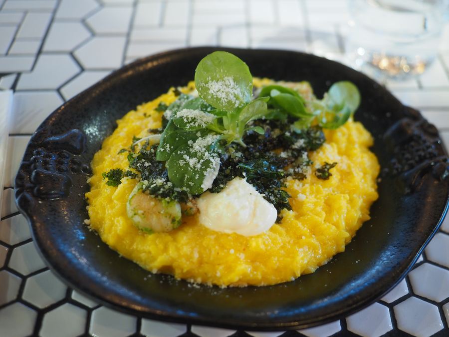 Saffron risotto with greens in a black cast-iron dish