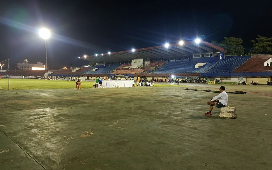 An empty pitch under floodlights at night